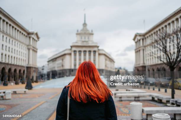 giovane donna che gode della vista del largo sulla piazza dell'indipendenza a sofia - dyed red hair foto e immagini stock