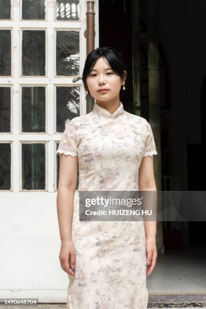 beautiful chinese woman in cheongsam standing next to a traditional building - child actor stock pictures, royalty-free photos & images