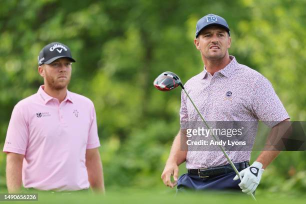 Bryson DeChambeau of the United States watches his tee shot on the fourth hole as Talor Gooch of the United States looks on during a practice round...