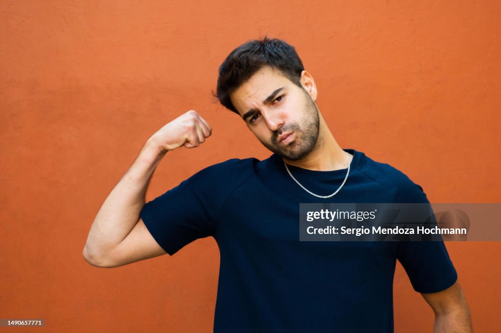 Latino man flexing his muscles and showing strength and determination