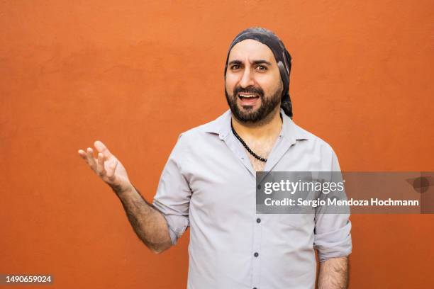 middle eastern, latino man with a bandana making a face looking uncertain, confused, perplexed, wtf - confused person stock pictures, royalty-free photos & images