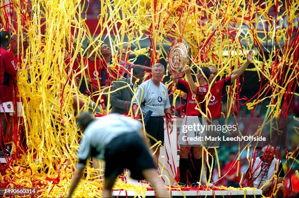 August 2003, Cardiff - FA Community Shield - Arsenal v Manchester United - Manchester United manager Alex Ferguson stands amongst red and yellow...