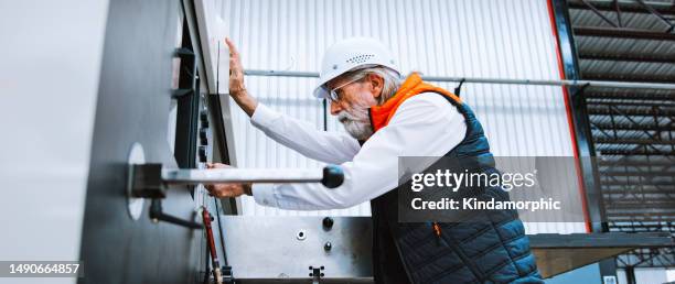 senior adult caucasian male technician engineer inspect manufacture machine, working in factory. technical maintenance engineering, logistic industry business, industrial job or people at work concept - werkende bejaarden stockfoto's en -beelden