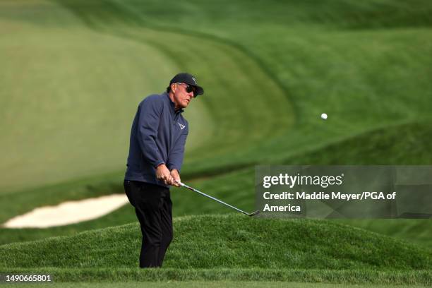 Phil Mickelson of the United States chips to the 12th green during a practice round prior to the 2023 PGA Championship at Oak Hill Country Club on...