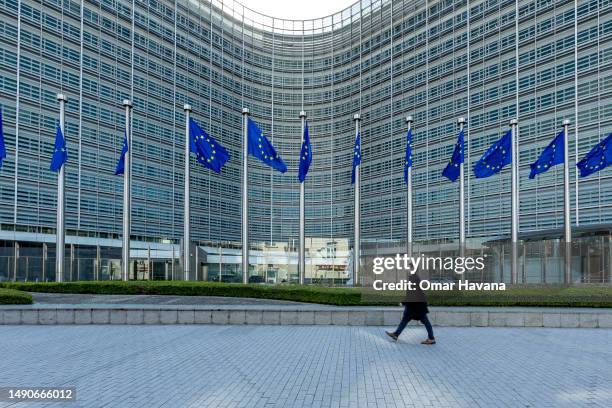 Man walks past the flags representing the EU member states at the Berlaymont building, named after the Convent of the Ladies of Berlaymont, which...