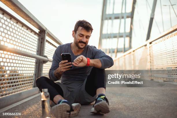 reloj de comprobación del corredor para la velocidad de carrera - checking sports fotografías e imágenes de stock