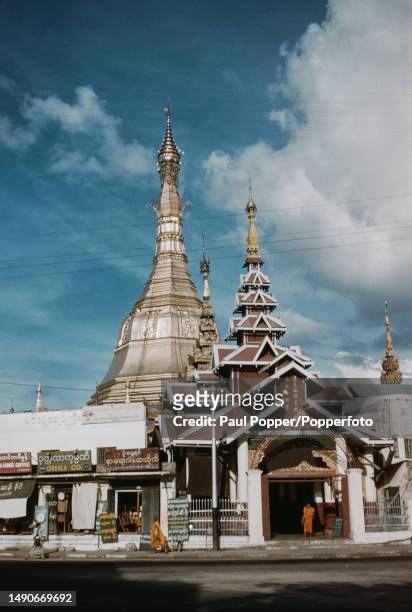 Monks stand outside the entrance to the Sule Pagoda, a Burmese Buddhist stupa in the centre of Rangoon capital city of Burma circa 1960.