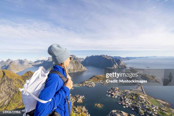 young woman on mountain top looks at the spectacular scenery, norway - lofoten en vesterålen stockfoto's en -beelden