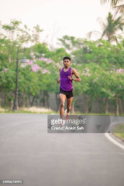 jeune athlète asiatique courant sur une route en béton et s’entraînant pour le marathon. - mens track photos et images de collection