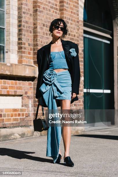 Charlene Davies wears Magda Butrym denim set, Prada sunglasses, Jacquemus bag and Culturesse accessories at Afterpay Australian Fashion Week 2023 at...