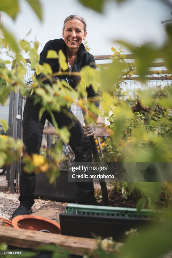 Glückliche frau, die im garten gräbt