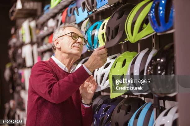 senior male customer in bicycle shop - protective sportswear stockfoto's en -beelden