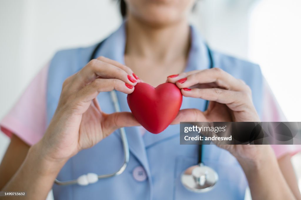 Retrato de una doctora sosteniendo el corazón del cardiólogo