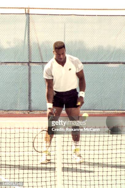 Award-winning professional baseball and football player Bo Jackson gets ready to serve a tennis ball holding a tennis racquet wearing Nike clothing...