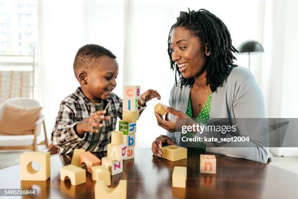 mom and son playing with wooden blocks - parent teacher stock pictures, royalty-free photos & images