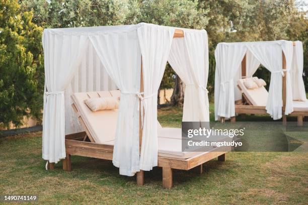 letto in legno - sedia vicino alla piscina sull'erba - outdoor umbrella foto e immagini stock