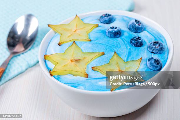 beautiful and healthy breakfast-oatmeal with carambola and blueberries with blue yogurt,romania - carambola stock pictures, royalty-free photos & images