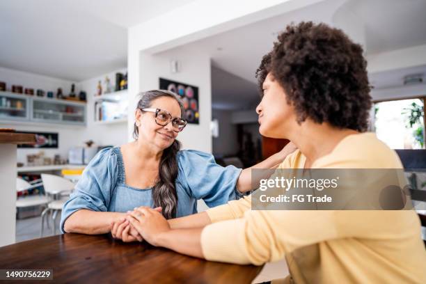 senior mother consoling her daughter at home - woman gratitude stock pictures, royalty-free photos & images