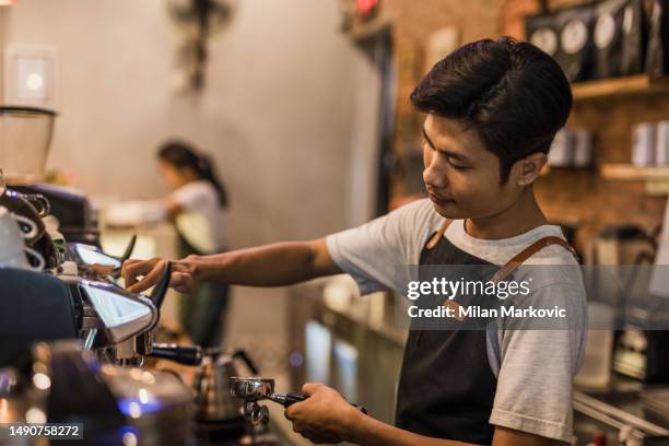 an asian man and woman working in a traditional cafe in bali. - pinafore dress stock pictures, royalty-free photos & images