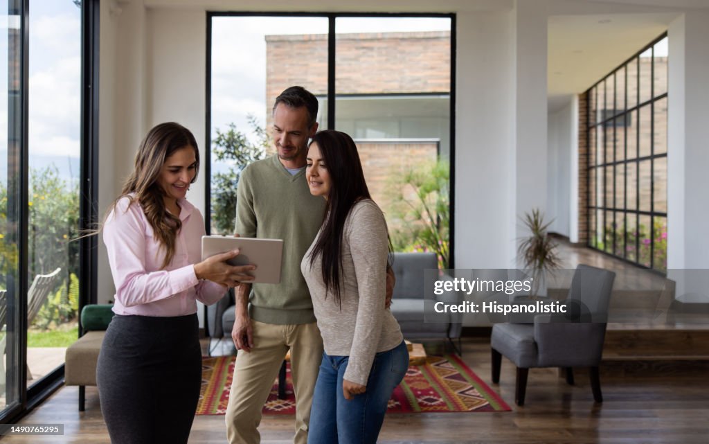 Agent immobilier montrant une maison à vendre à un couple