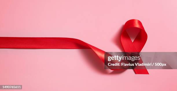 red ribbon symbol of world aids day on pink background banner format,romania - world aids stock pictures, royalty-free photos & images