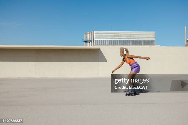 joven afroamericana patinando en zona urbana - patín en línea fotografías e imágenes de stock