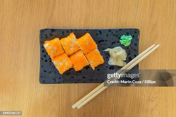 set of sushi roll with red caviar on black tray with chopsticks on wooden table,top view traditional japanese food,romania - fresh wasabi stockfoto's en -beelden