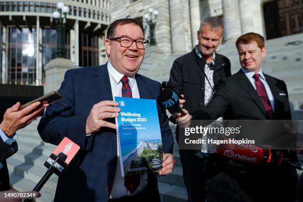 Finance Minister Grant Robertson speaks to media while holding a copy of Budget 2023 during a photo opportunity at Parliament on May 17, 2023 in...