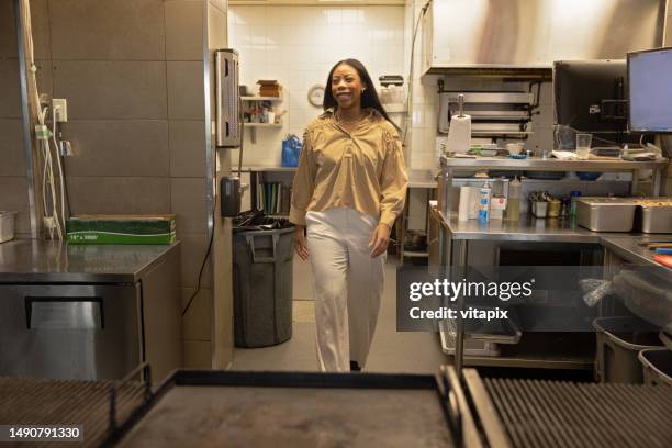 restaurant manager walking through kitchen - restaurant kitchen fridge stock pictures, royalty-free photos & images