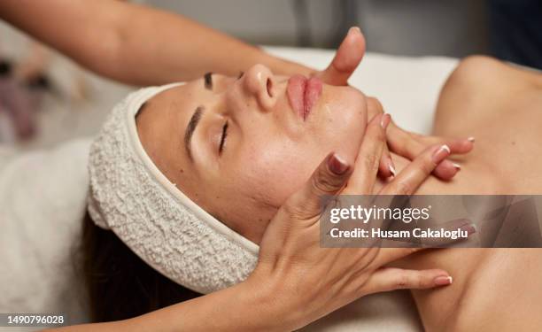 young woman getting skin care, getting facial massage after treatment. - facial massage stock pictures, royalty-free photos & images