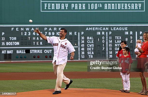 Boston Red Sox catcher Jason Varitek throws out the ceremonial first pitch, accompanied by his wife and daughters during a pre-game ceremony honoring...