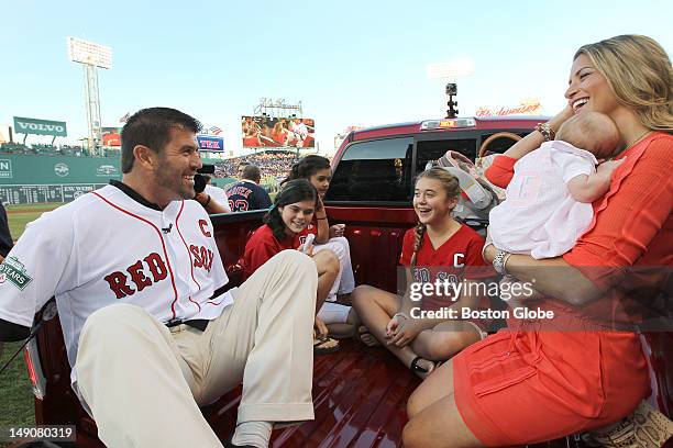 Boston Red Sox catcher Jason Varitek sits in the bed of a new truck given to him by the Boston Red Sox organization accompanied by his wife and...