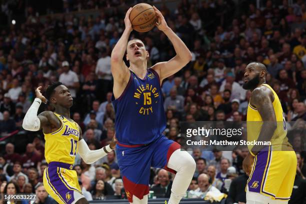 Nikola Jokic of the Denver Nuggets shoots the ball between Dennis Schroder and LeBron James of the Los Angeles Lakers during the third quarter in...