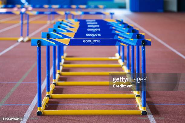 hürden auf der stadionlaufbahn - hurdling track event stock-fotos und bilder