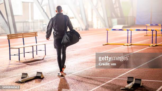sportsman with sport bag at stadium - indoor track and field stock pictures, royalty-free photos & images