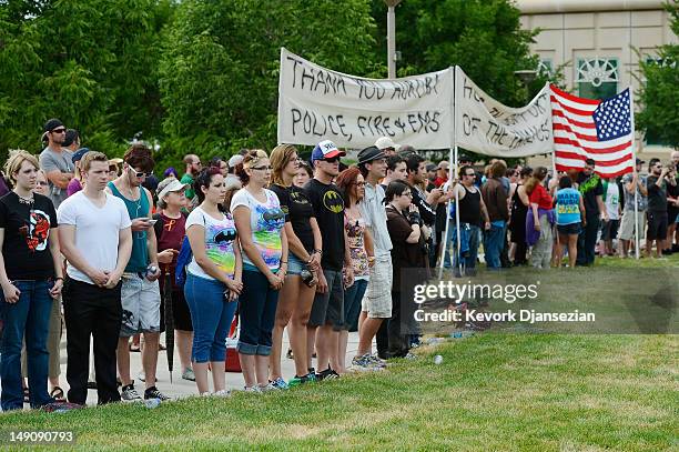 Members of the crowd, many in Batman t-shirts, create a human wall to block the Westboro Baptist Church from protesting the prayer vigil for the...