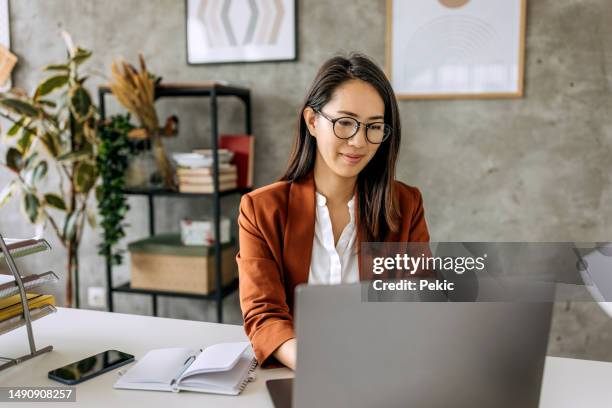bien vestida hermosa mujer de negocios mediana adulta que trabaja desde la oficina en casa - usar el ordenador fotografías e imágenes de stock