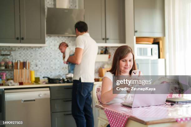 father helping his wife with newborn baby at kitchen - new husband stock pictures, royalty-free photos & images