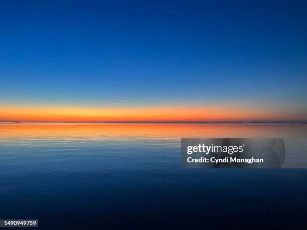 sunset glowing across the chesapeake bay - orizzonte foto e immagini stock