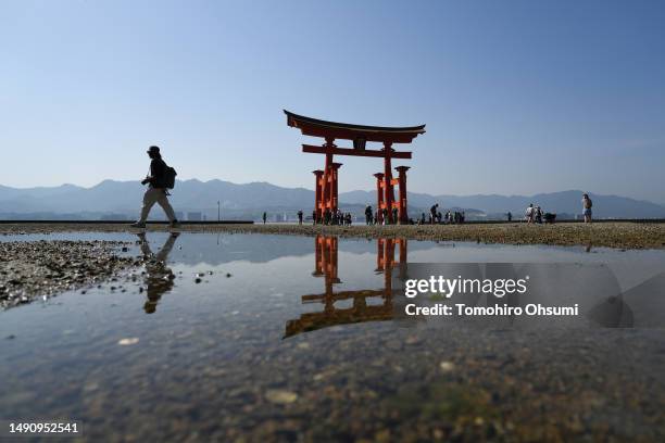 Tourist walks past the Grand Torii Gate at Itsukushima Shrine on Miyajima Island where leaders of the Group of 7 countries are scheduled to visit on...
