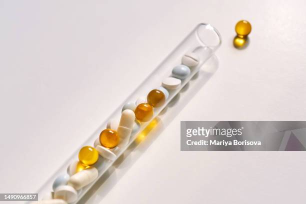 tablets, vitamins and dietary supplements in a test tube on a light background. - vitamins and minerals imagens e fotografias de stock