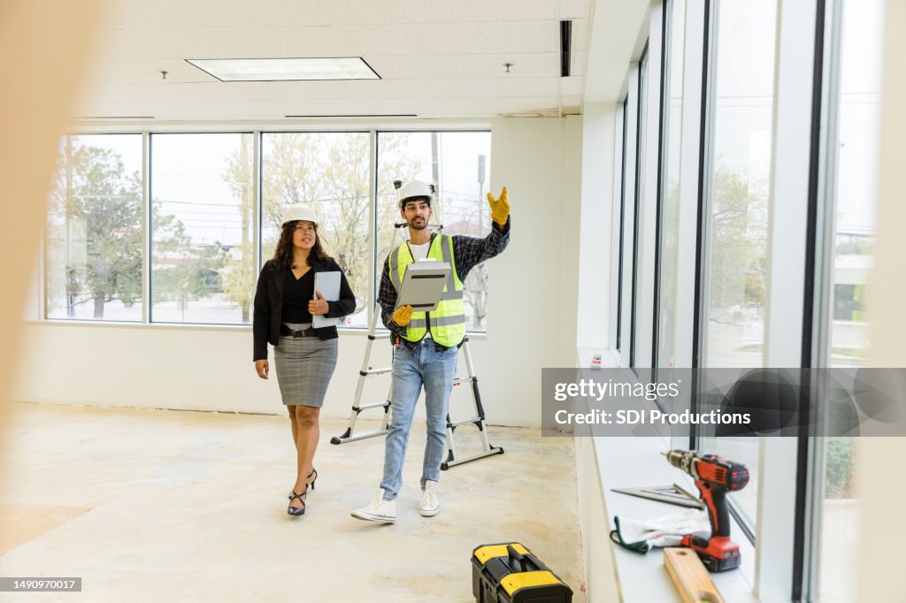 職長の監督者が女性市職員と面談し、新館のスケジュールを確認