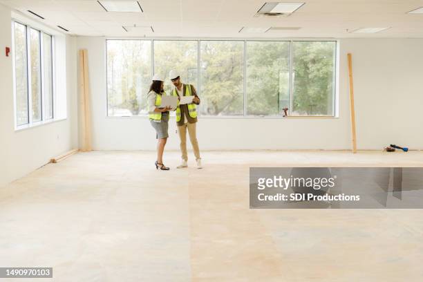 business professionals meet at the construction site to compare notes and inspect the project tasks - flooring contractor stock pictures, royalty-free photos & images
