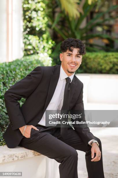 2023 high-school senior young man well-dressed in a black suit, white dress shirt, black tie & black suede shoes, an18-year-old cuban-american with brown hair & brown eyes looking fresh & sharp in a suit & tie in a classy location in palm beach, florida - green high heels stock pictures, royalty-free photos & images