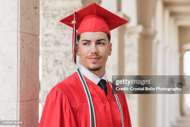2023 high-school senior young man in a red graduation cap & gown with three honors tassels, a well-dressed 18-year-old cuban-american with brown hair & brown eyes looking fresh & sharp in a suit & tie in a classy location in palm beach, florida - high school senior stock pictures, royalty-free photos & images