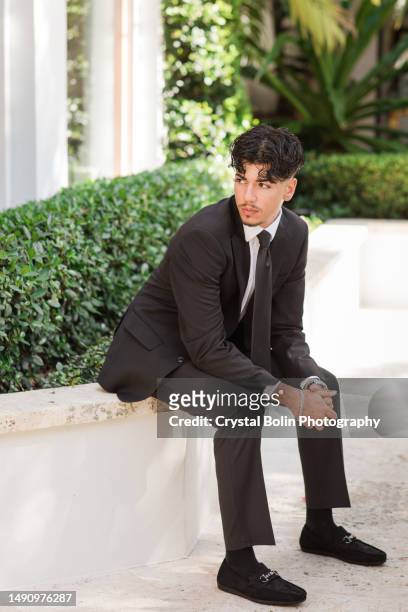 2023 high-school senior young man well-dressed in a black suit, white dress shirt, black tie & black suede shoes, an18-year-old cuban-american with brown hair & brown eyes looking fresh & sharp in a suit & tie in a classy location in palm beach, florida - green high heels stock pictures, royalty-free photos & images