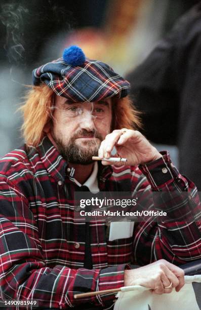 November 1999, Glasgow - European Championship Play-off - Scotland v England - A Scotland fan in a tartan jacket and a ginger wig smokes a cigarette.