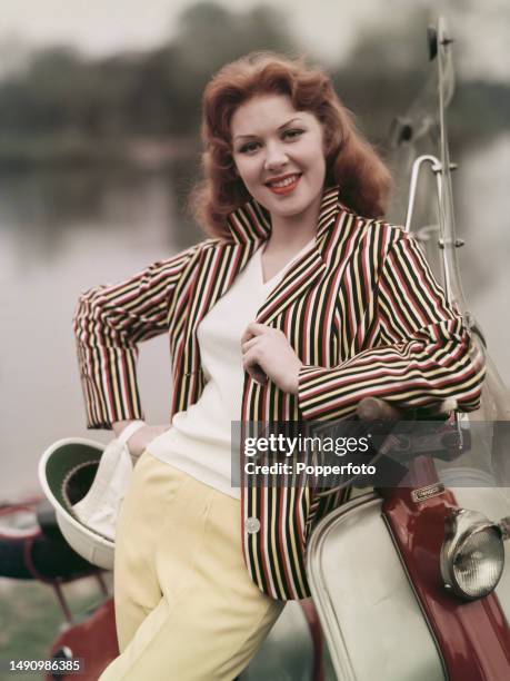English singer Pat Laurence posed beside a motor scooter, she wears a sailcloth striped blazer and pale yellow drip-dry slacks, England 29th August...
