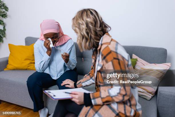 young black woman opens up to her caring caucasian psychotherapist - hijab stock pictures, royalty-free photos & images