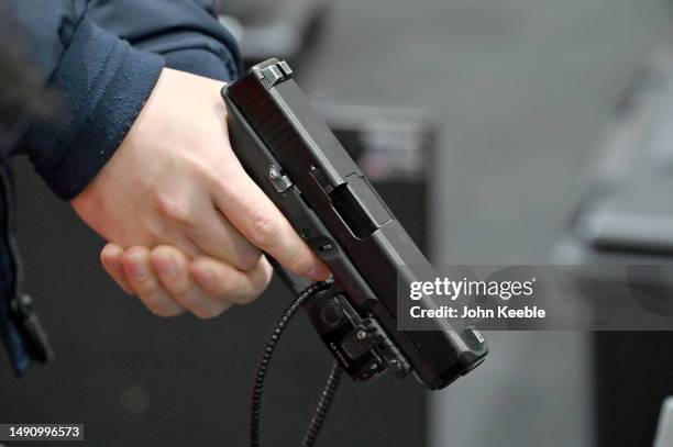 Visitor holds a Glock 17 handgun at the British Transport Police stand during the Counter Terror And Forensics Europe Expo 2023 at ExCel on May 17,...